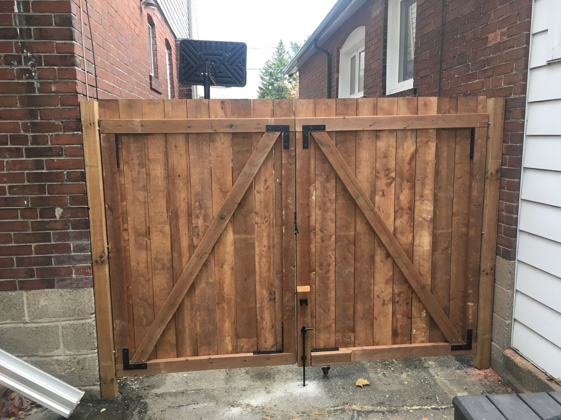 a wooden gate is sitting in front of a brick building