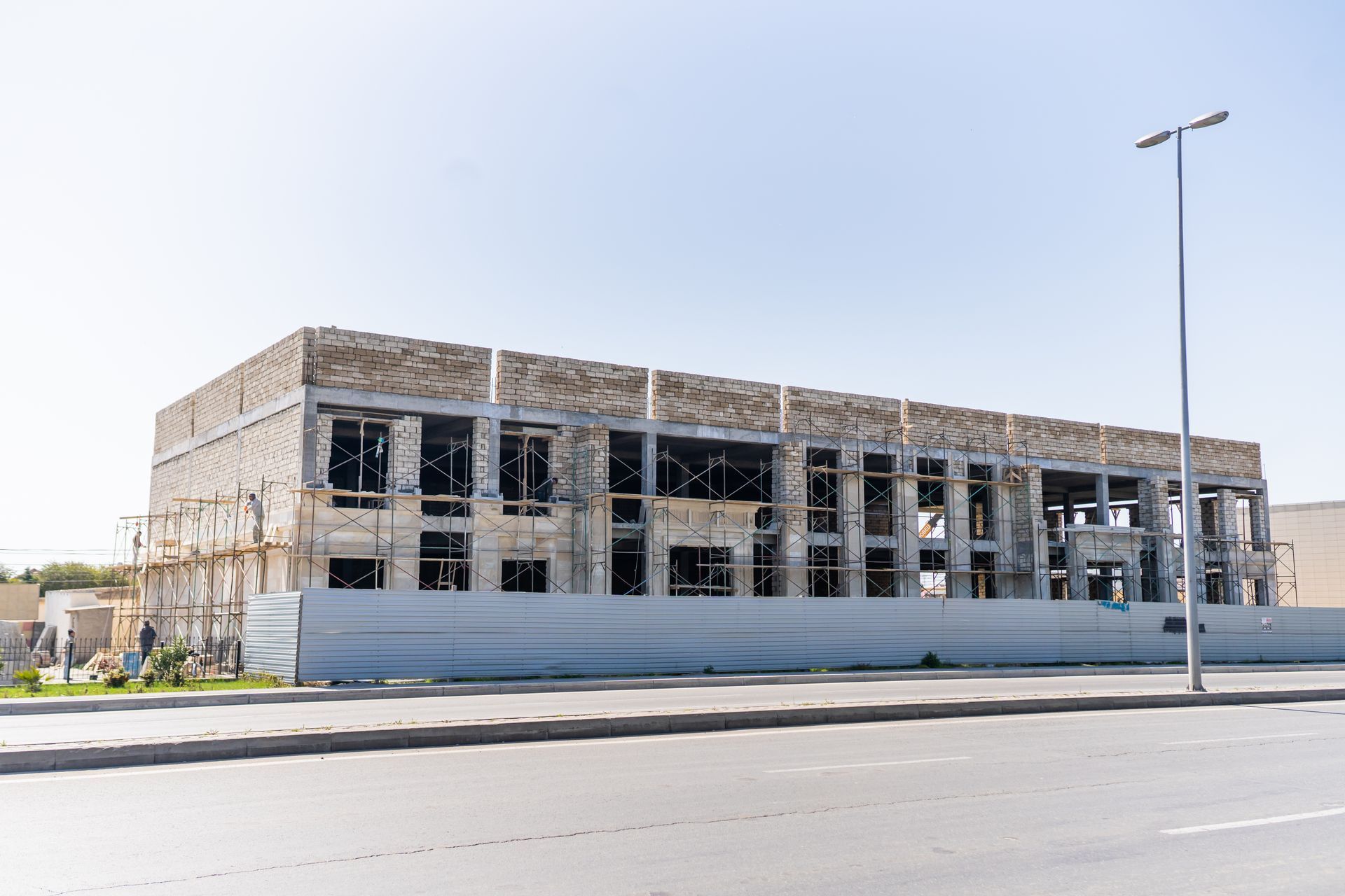 A large building is being built next to a road.