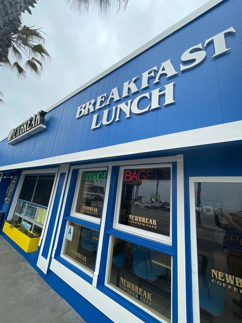 Blue and white diner "Breakfast Lunch" exterior. Windows display "Newbreak" signage.