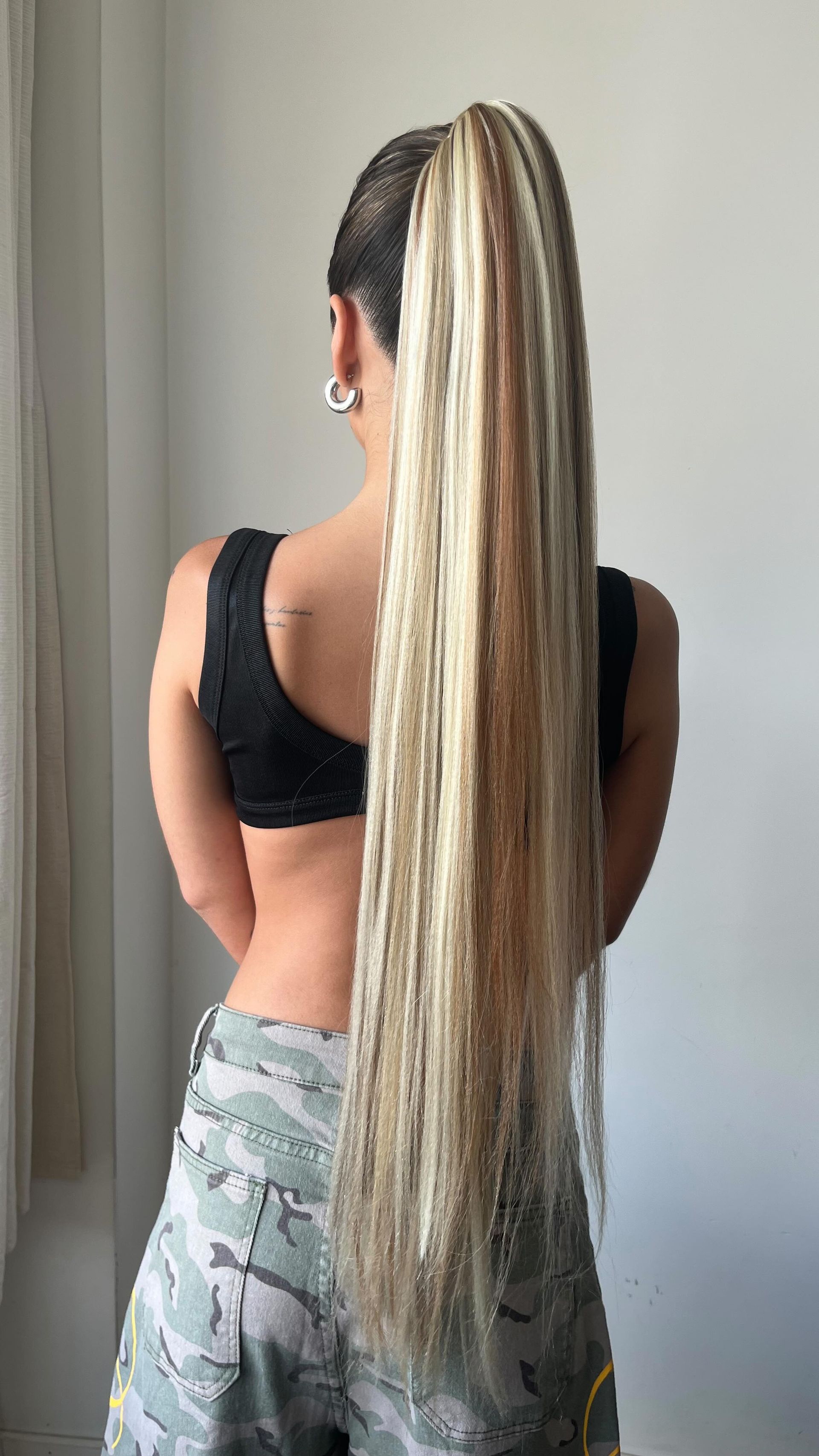 Mujer de pie de espaldas a la cámara, mostrando una melena rubia