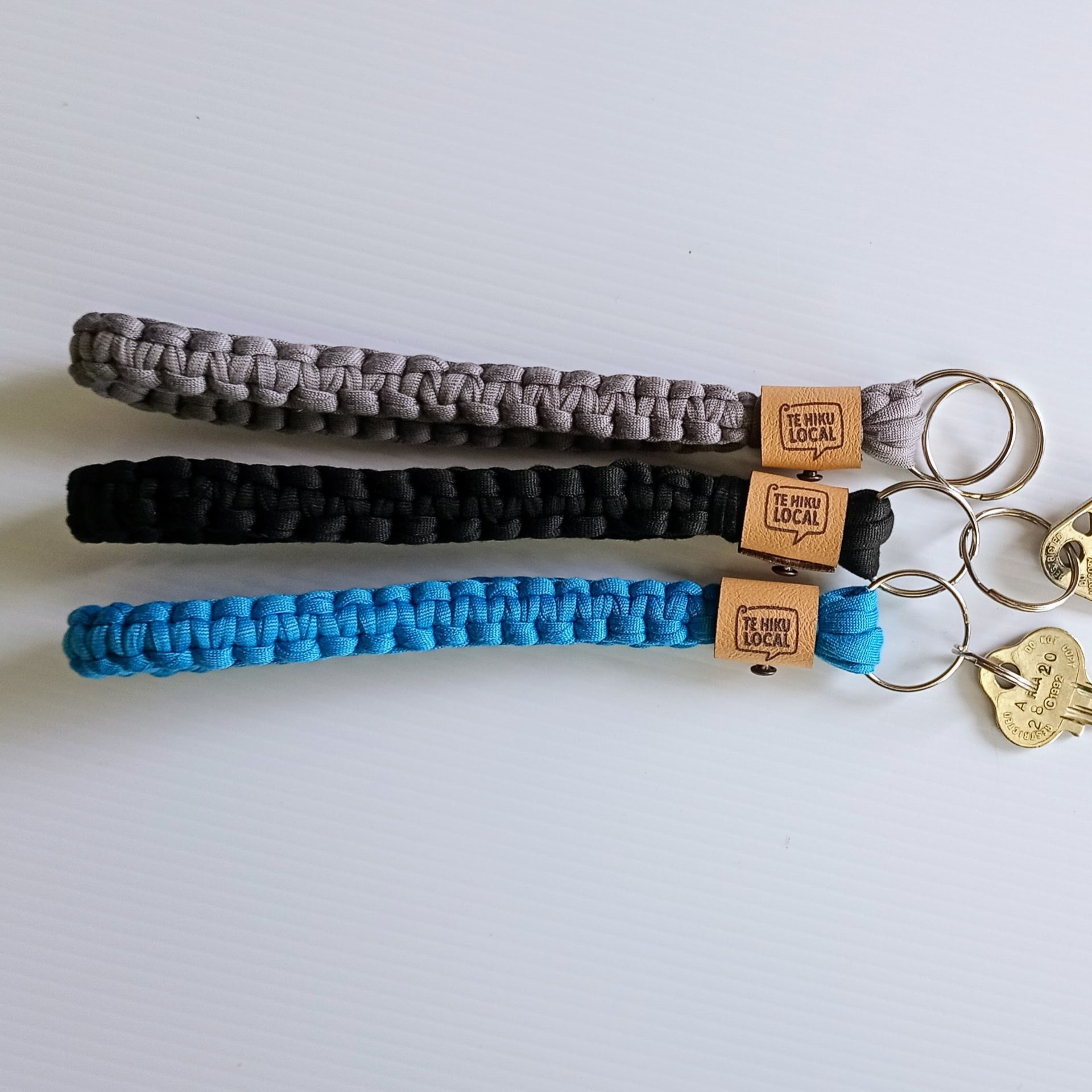 Blue woven lanyard with keys and a brown tag that reads