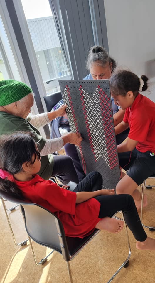 A group of people are sitting in chairs holding a piece of paper.