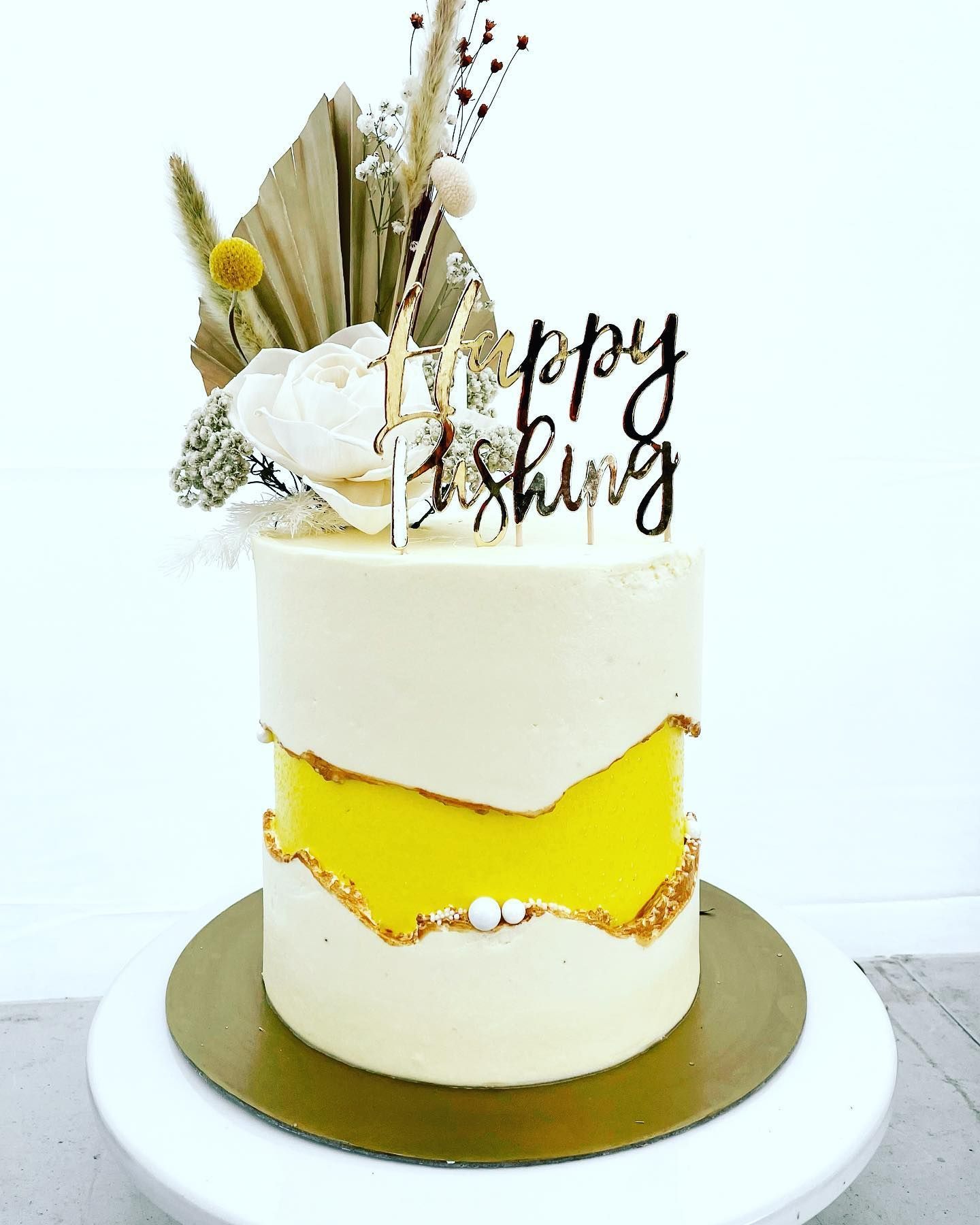 Woman holding a basket of fresh tomatoes, eggplant, and pepper. Outdoors, dog nearby.