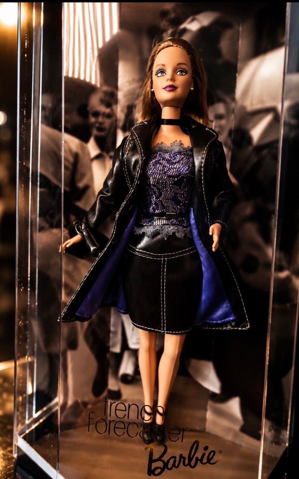 Barbie doll in a black and purple outfit, posed in front of a mirrored background