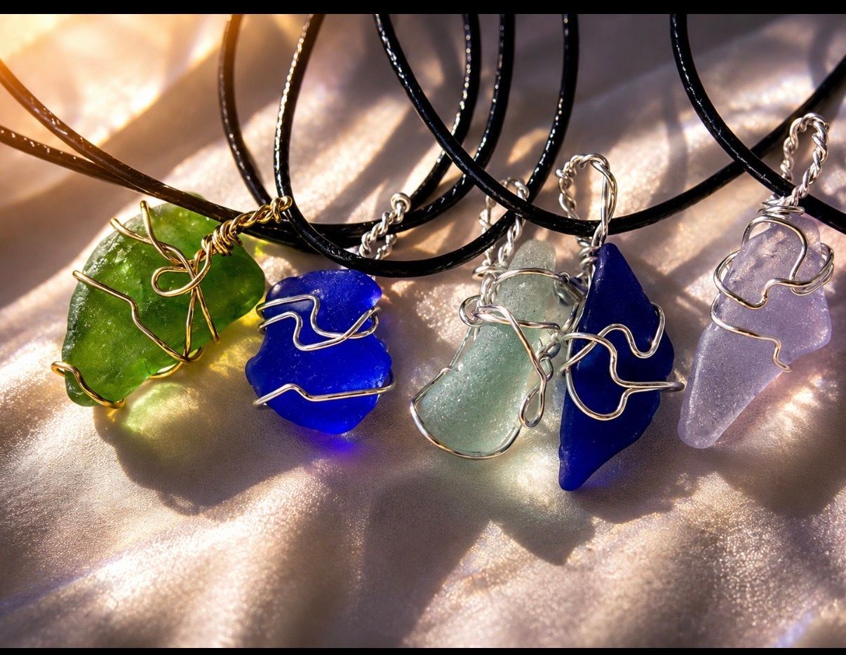 Five wire-wrapped gemstone pendants on black cords, in green, blue, gray, and purple.