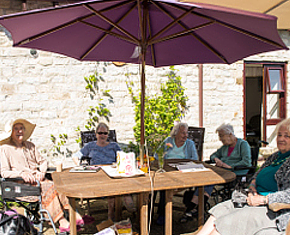 elderly people sitting and chatting outdoors