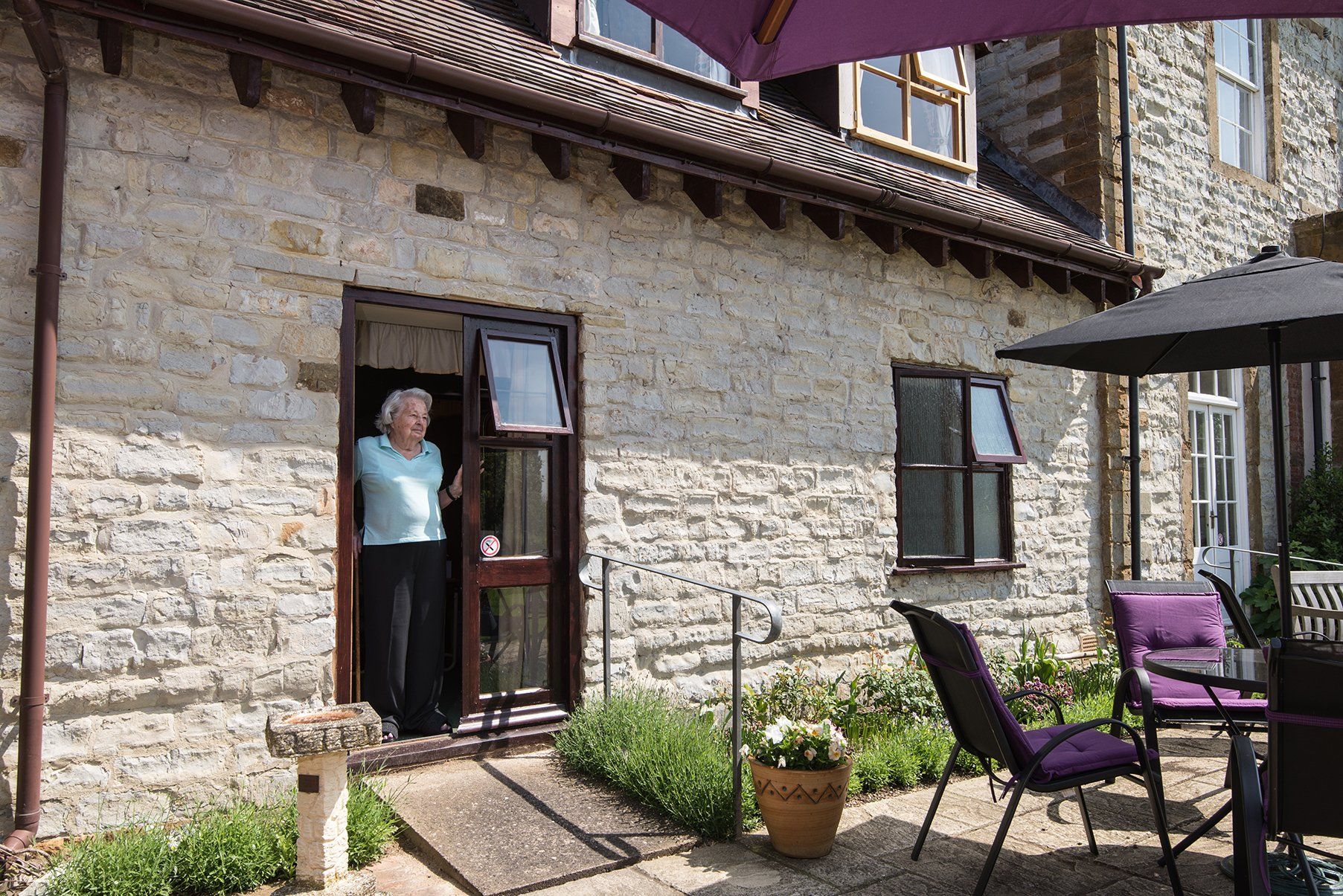 an elderly man standing near the front door and watching outside