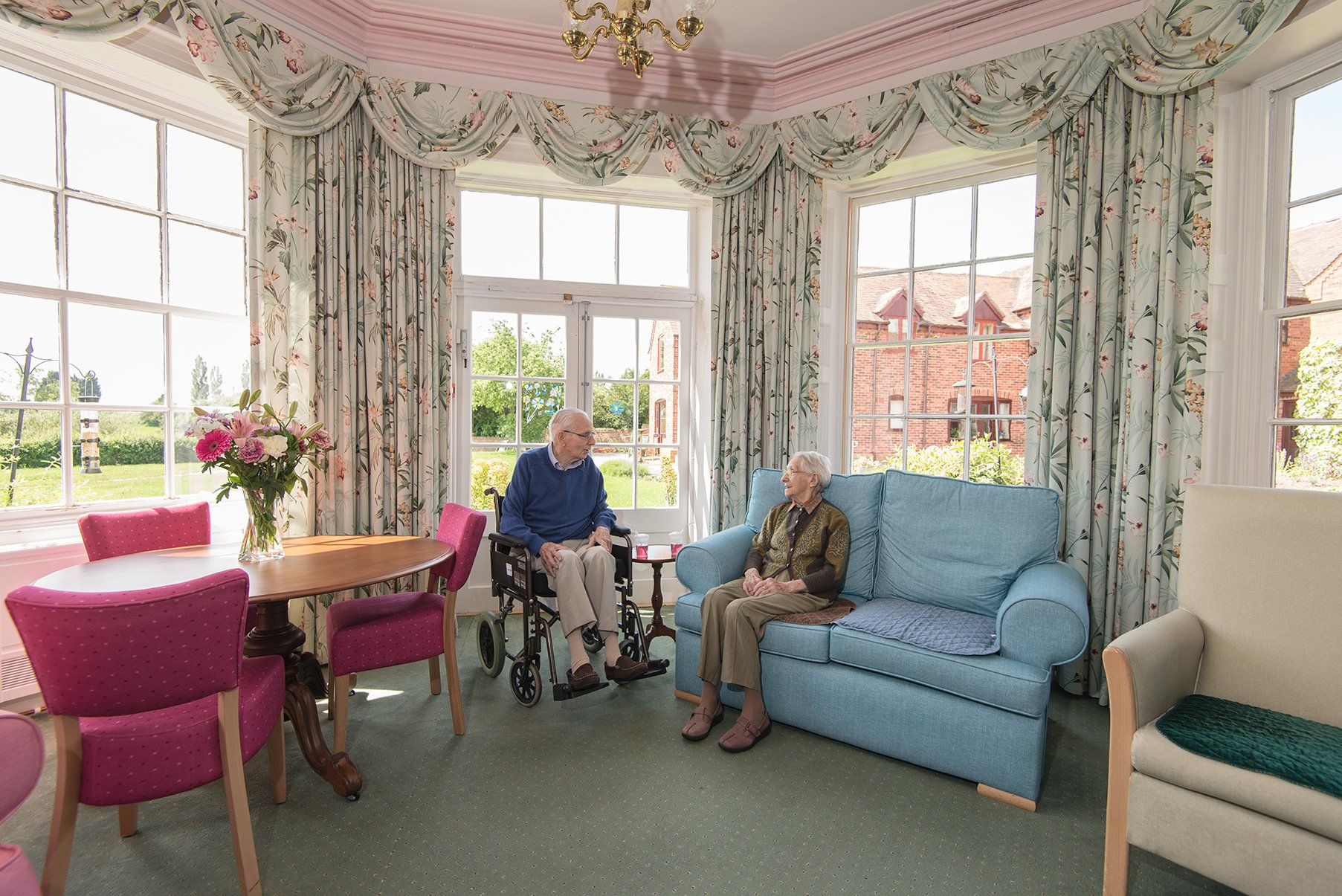 elderly people sitting and talking at the living area
