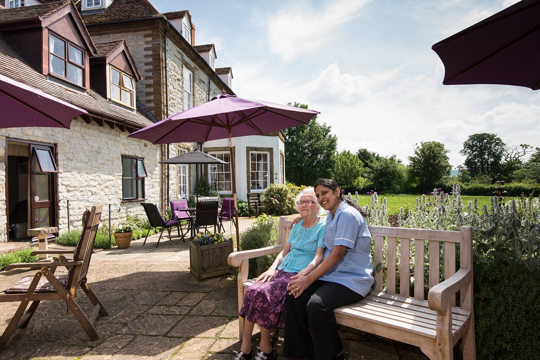 a carer sitting with the elderly lady at the garden area