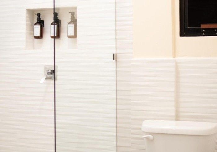 A bathroom with a toilet and a shower with a glass door.