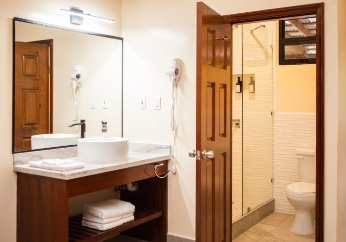 A bathroom with a sink , toilet and mirror.