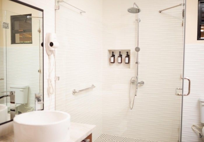 A bathroom with a sink , toilet , shower and mirror.