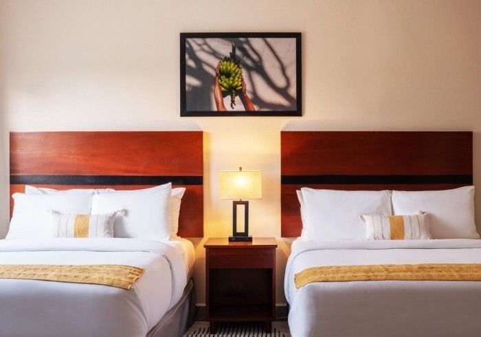 A hotel room with two beds and a lamp