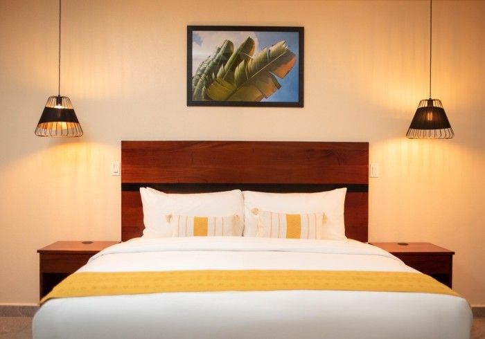 A hotel room with a bed and a picture on the wall above it