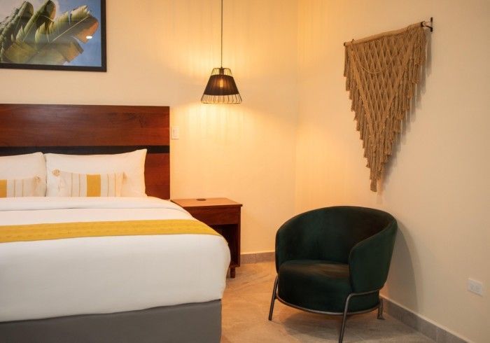 A hotel room with a bed and a chair.