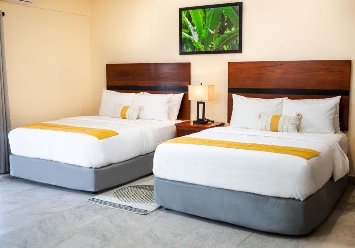 A hotel room with two beds and a picture on the wall