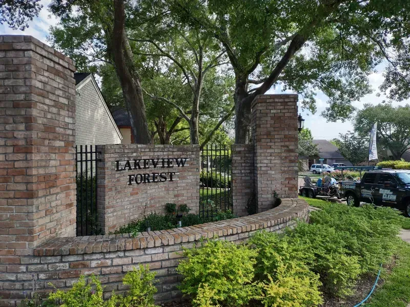 Sign for Lakeview Forest, a residential area, with brick columns, wrought iron gate, and landscaping.