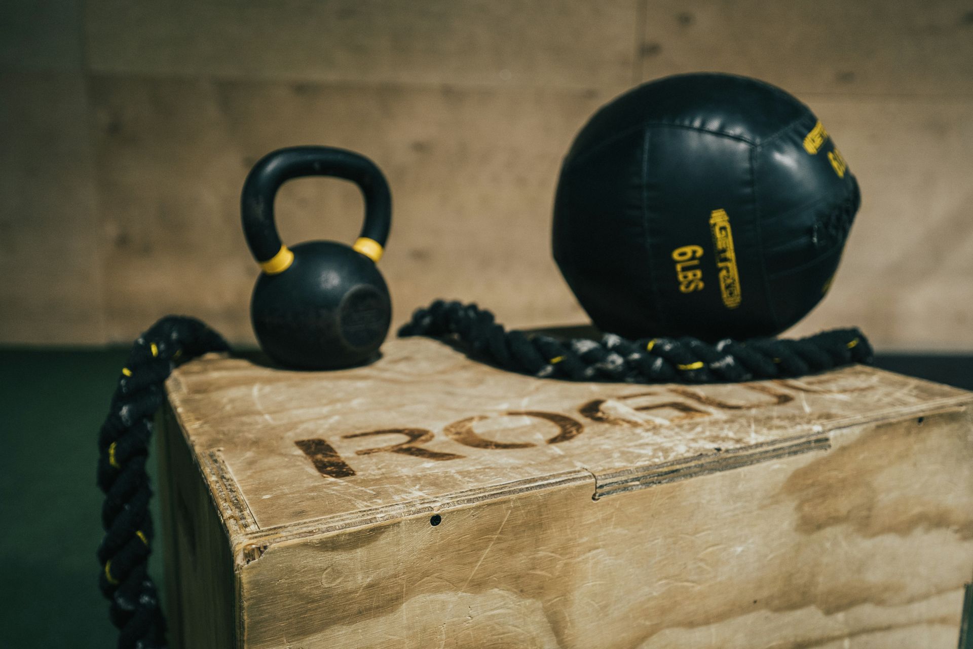 Gym interior with weightlifting equipment, arches, and a boxing bag, in dark tones.