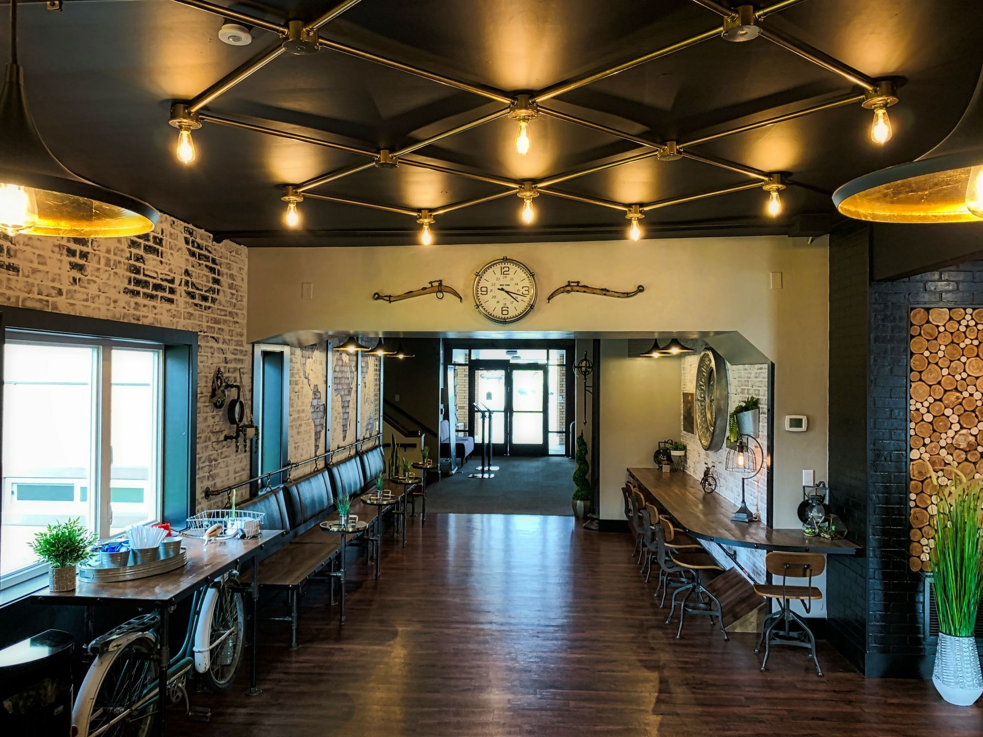 A large room with tables and chairs and a clock on the wall.