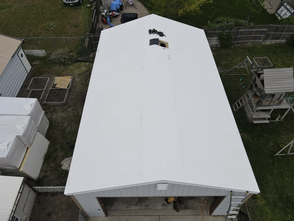 An aerial view of a garage with a white roof