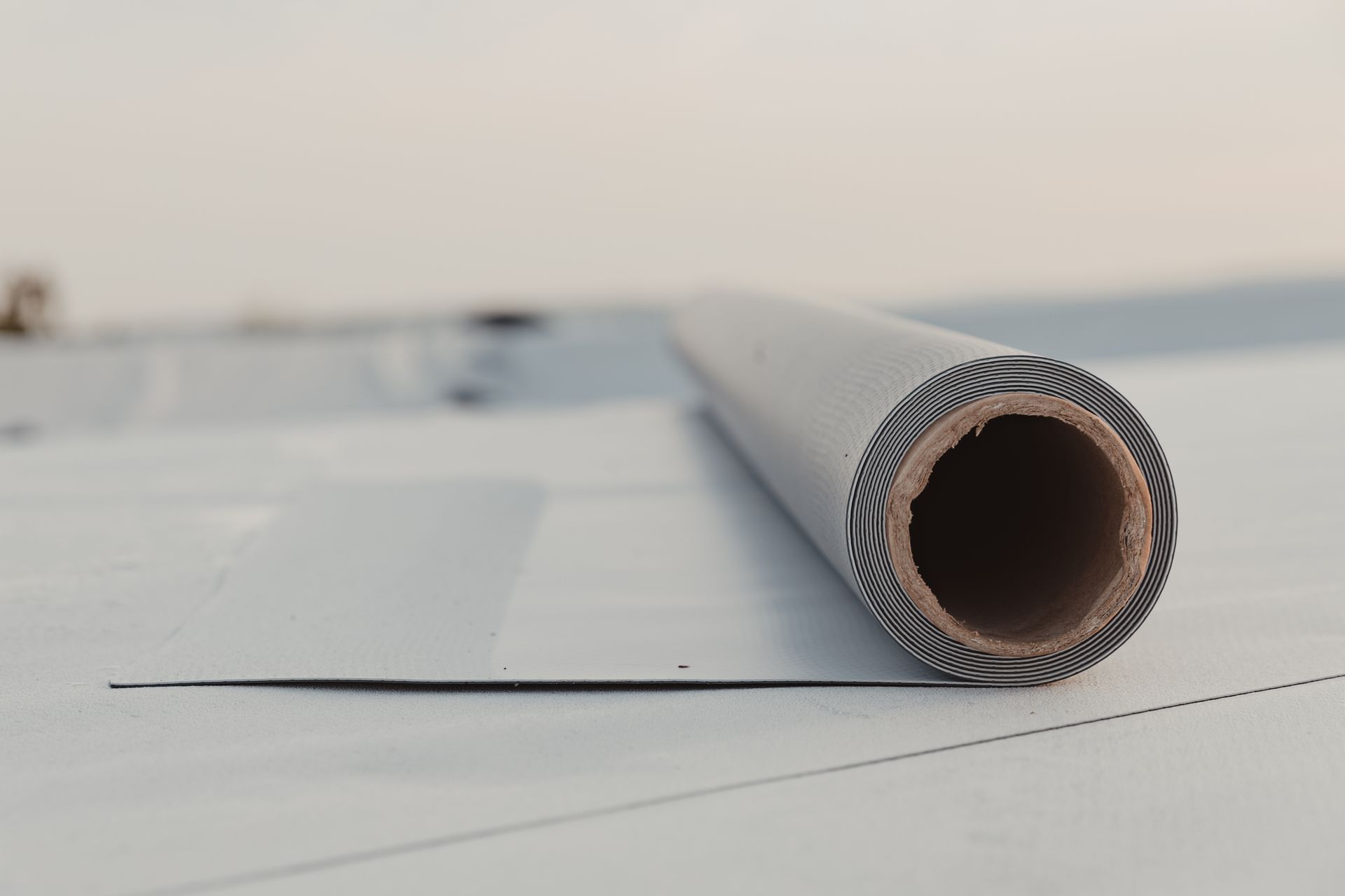 A roll of roofing material is sitting on top of a roof.