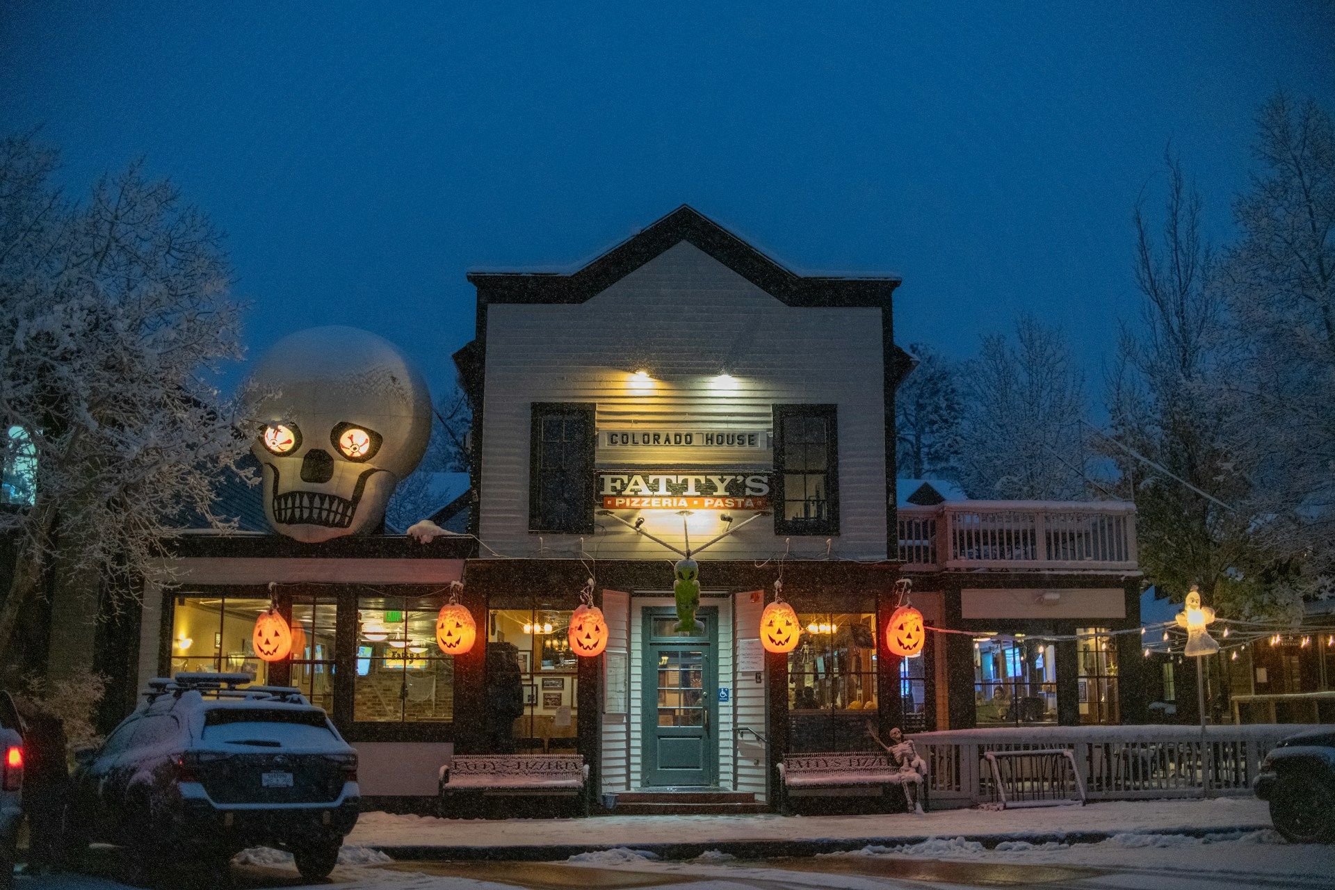 A building with a large skull on top of it is decorated for halloween.