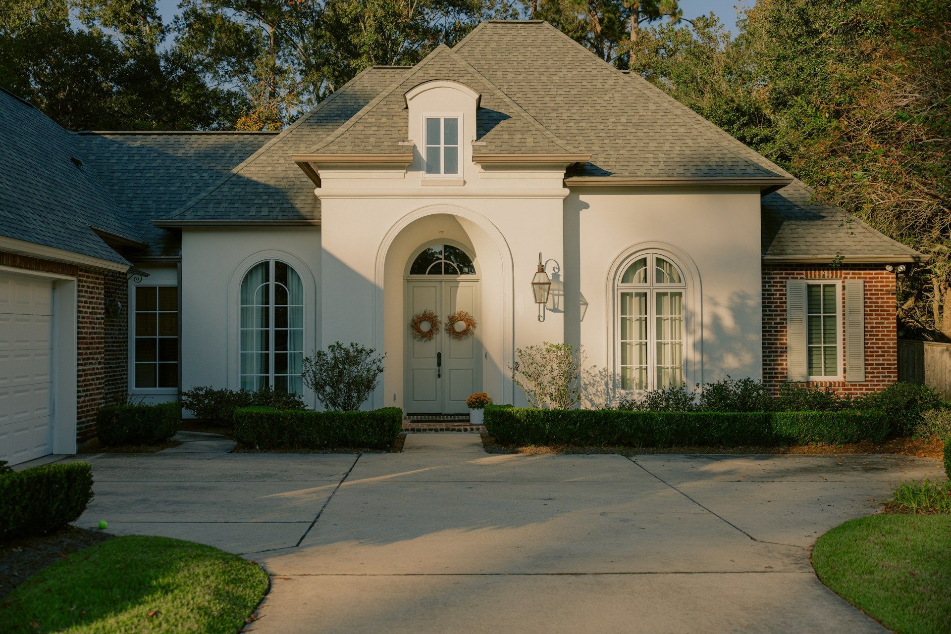 A white house with a gray roof and a driveway