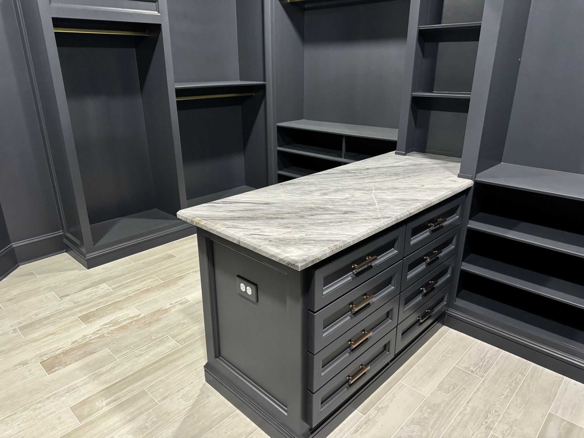 A walk in closet with a large island in the middle.