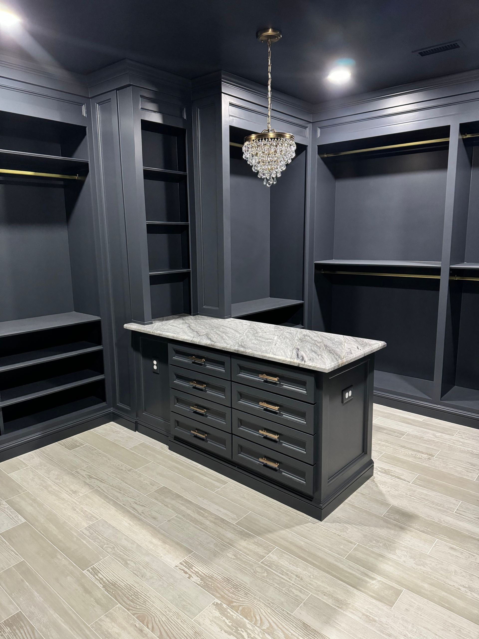 A walk in closet with a large island in the middle