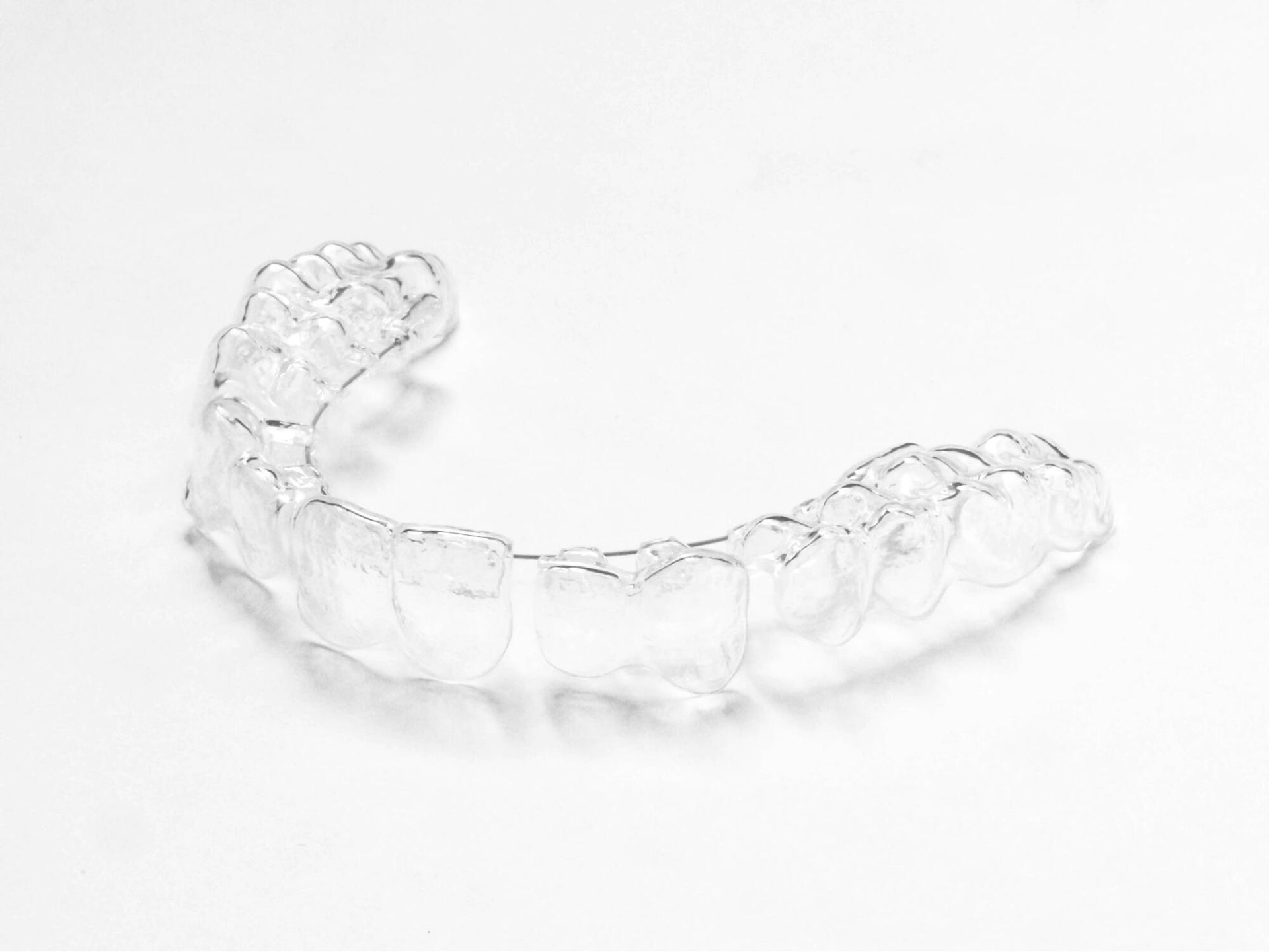 Clear transparent dental aligner on a white background