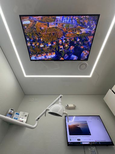 A dental office with a dental chair and a television on the wall.