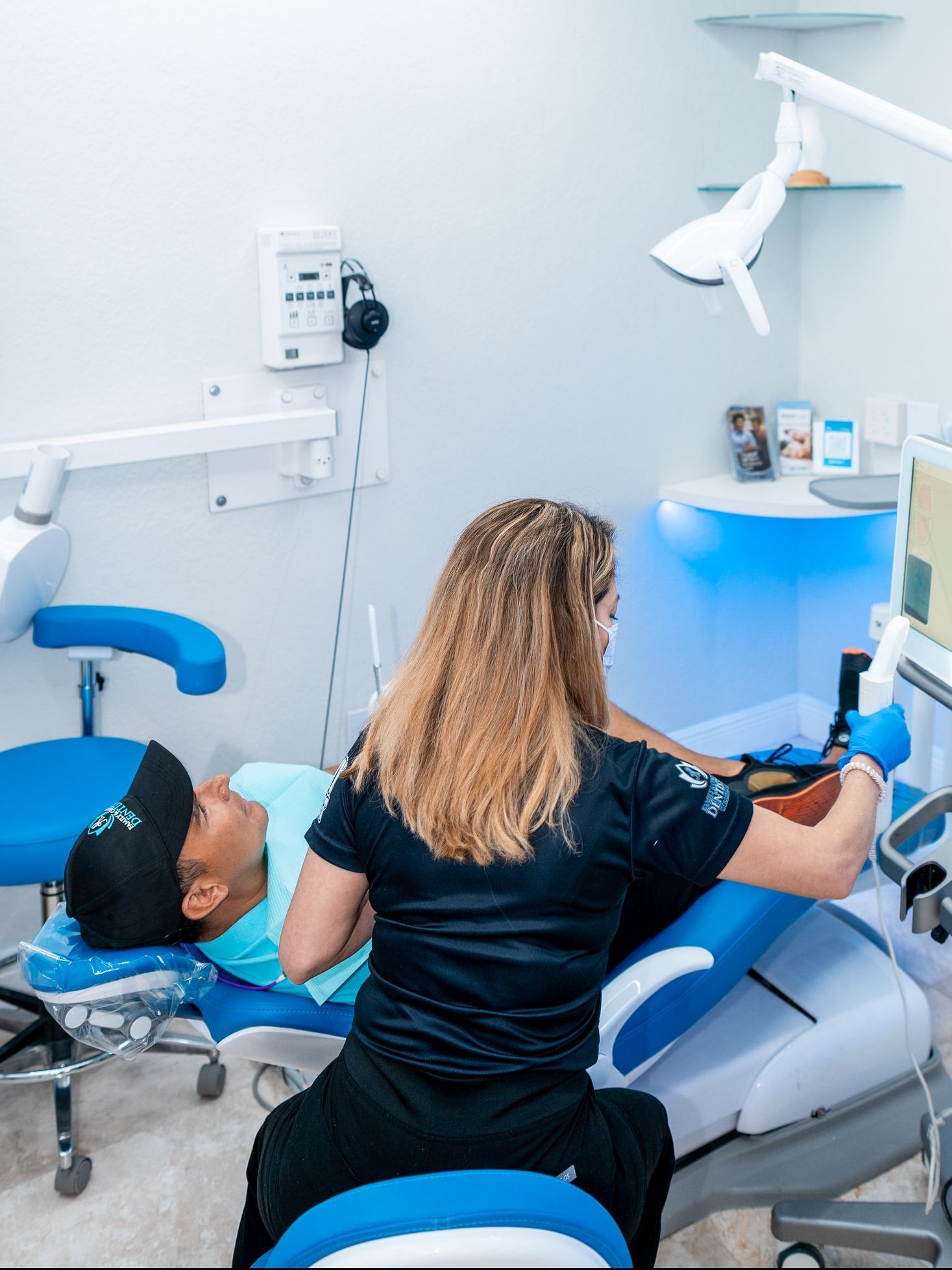 A woman is getting her teeth examined by a dentist in a dental office.
