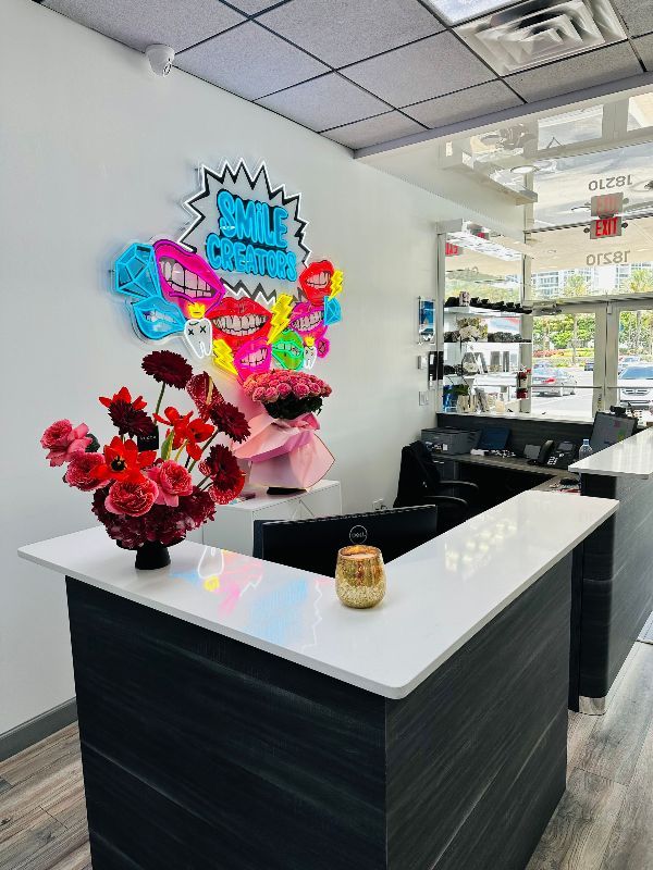 A reception desk in a salon with a vase of flowers on it.