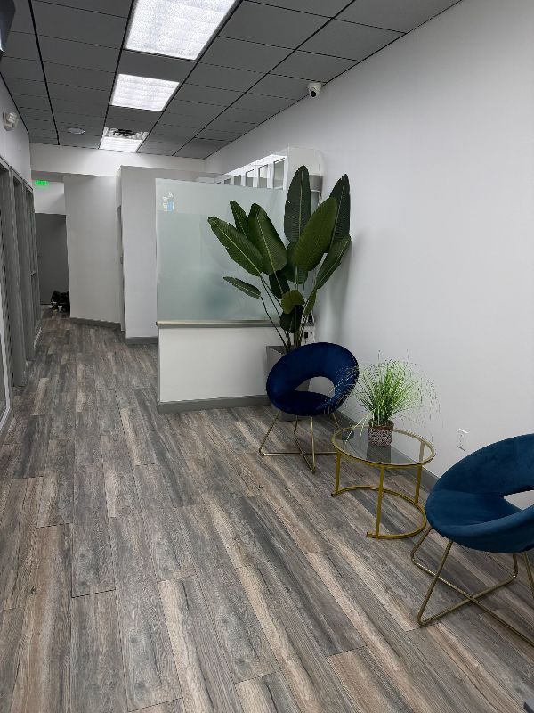 A dental office with a red chair and a tv on the wall