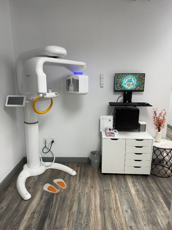 A long hallway in a dental office with wooden floors and white cabinets.
