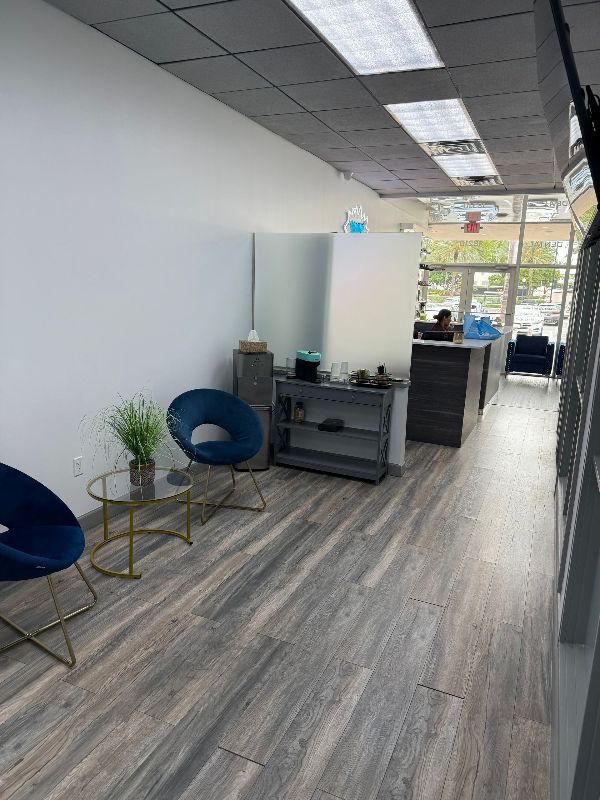 A waiting room with chairs and a table in a store.
