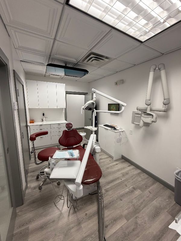 A dental office with a dental chair and x-ray machine.