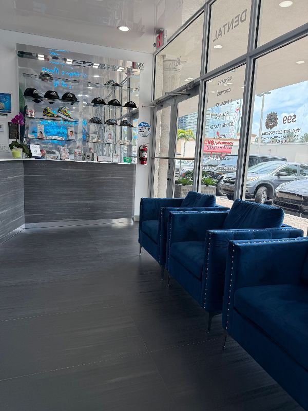 A waiting room with blue chairs and a counter in a store.