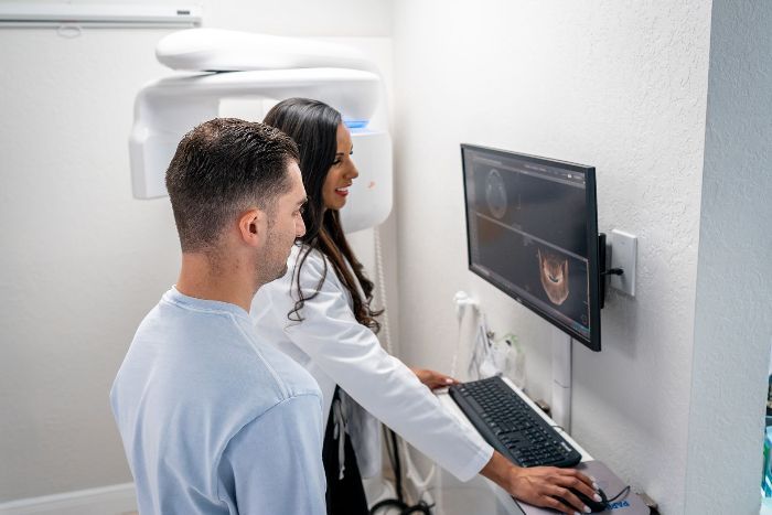 A man and a woman are looking at a computer screen.