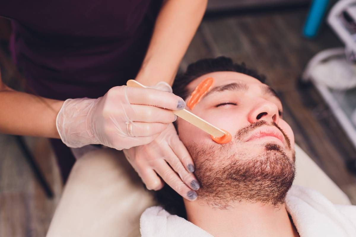 Someone getting his face waxed in specific areas at Lux Hair Bar near Lexington, Kentucky (KY)