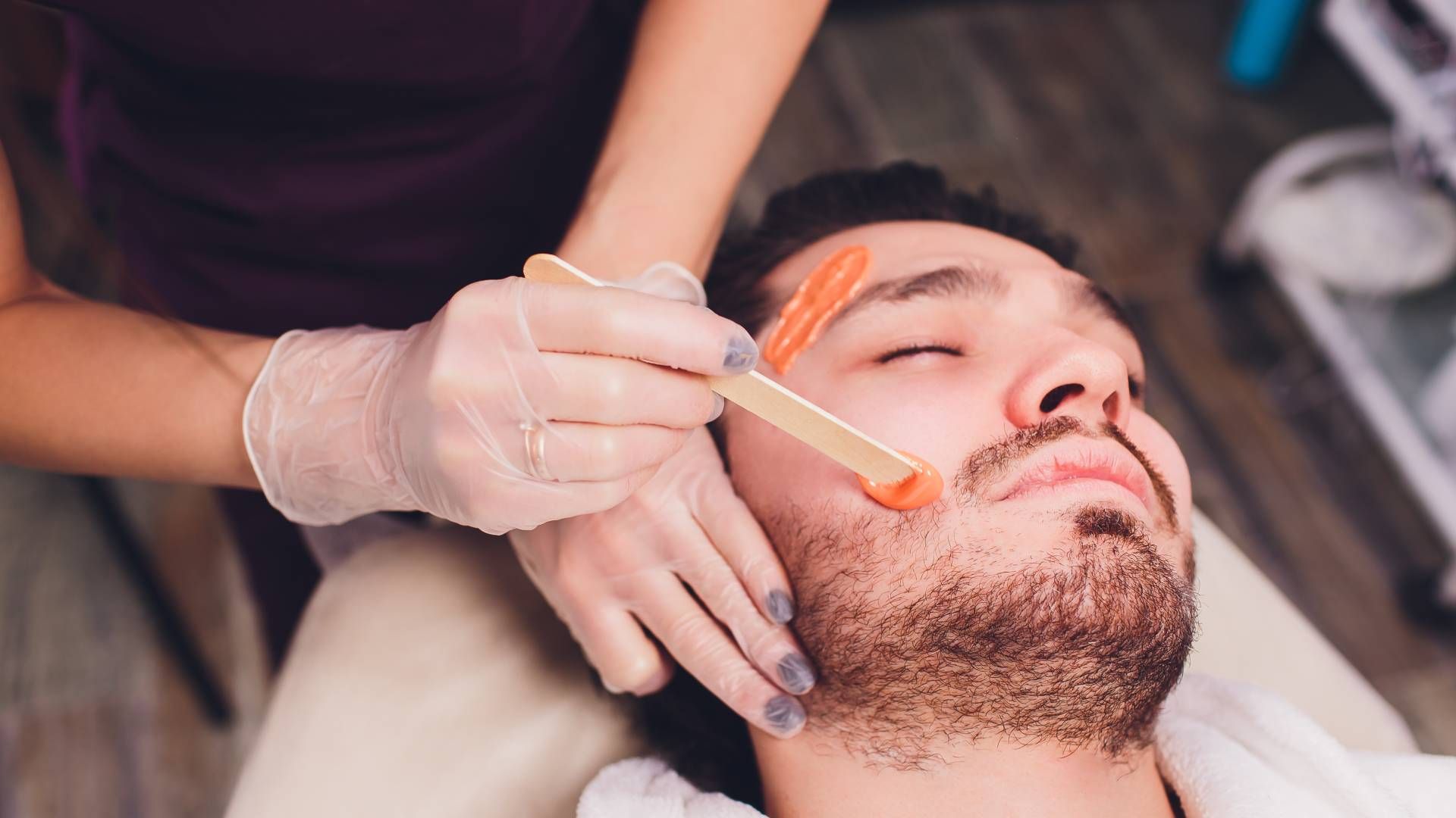 Someone getting his face waxed in specific areas at Lux Hair Bar near Lexington, Kentucky (KY)