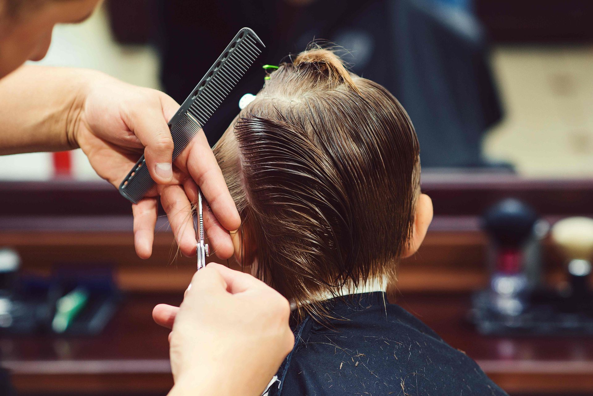  A kid getting a new haircut from a professional  at Lux Hair Bar near Lexington, Kentucky (KY)