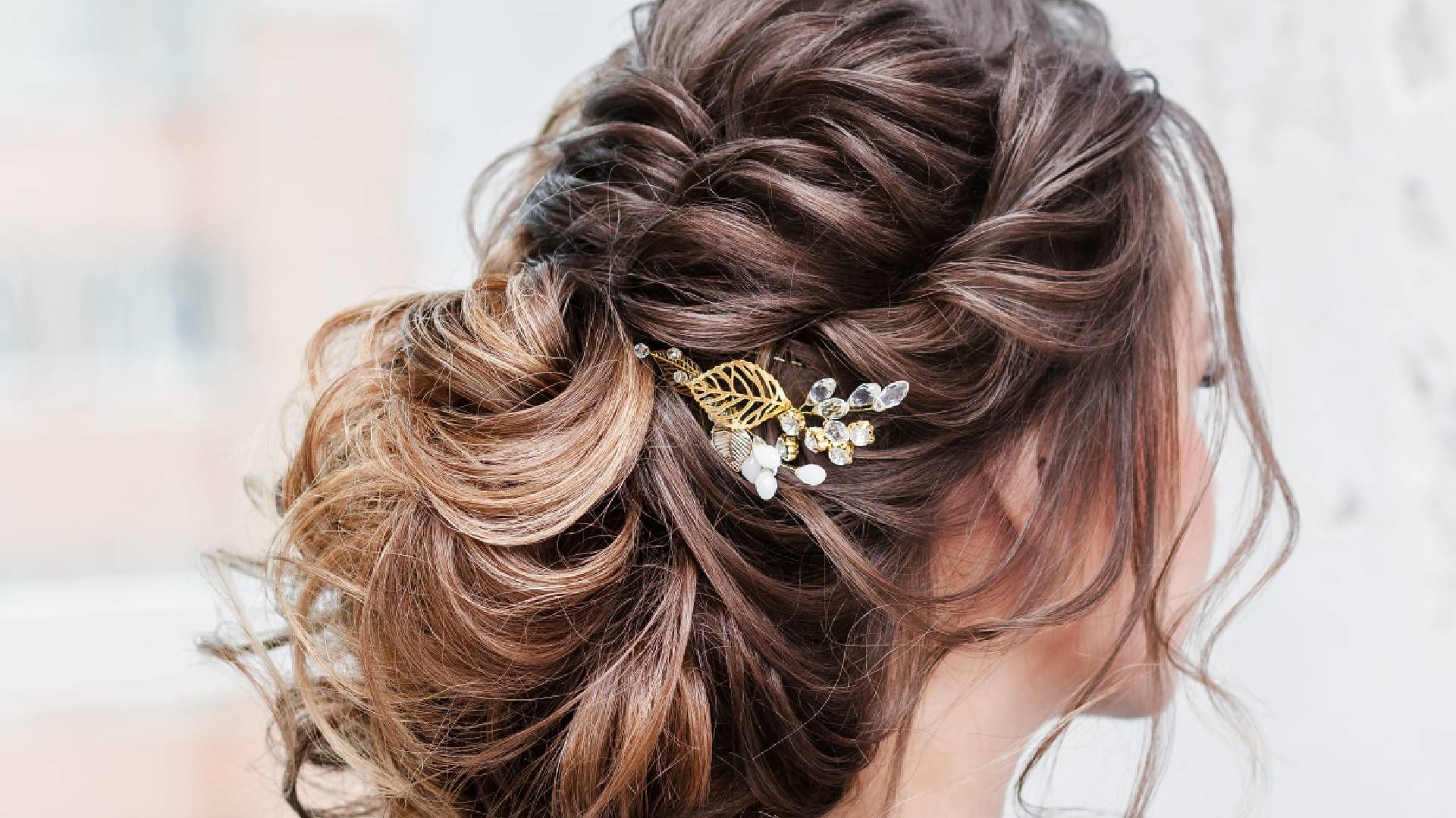 A woman with an elegant hairstyle and floral hair accessory at Lux Hair Bar near Lexington, Kentucky