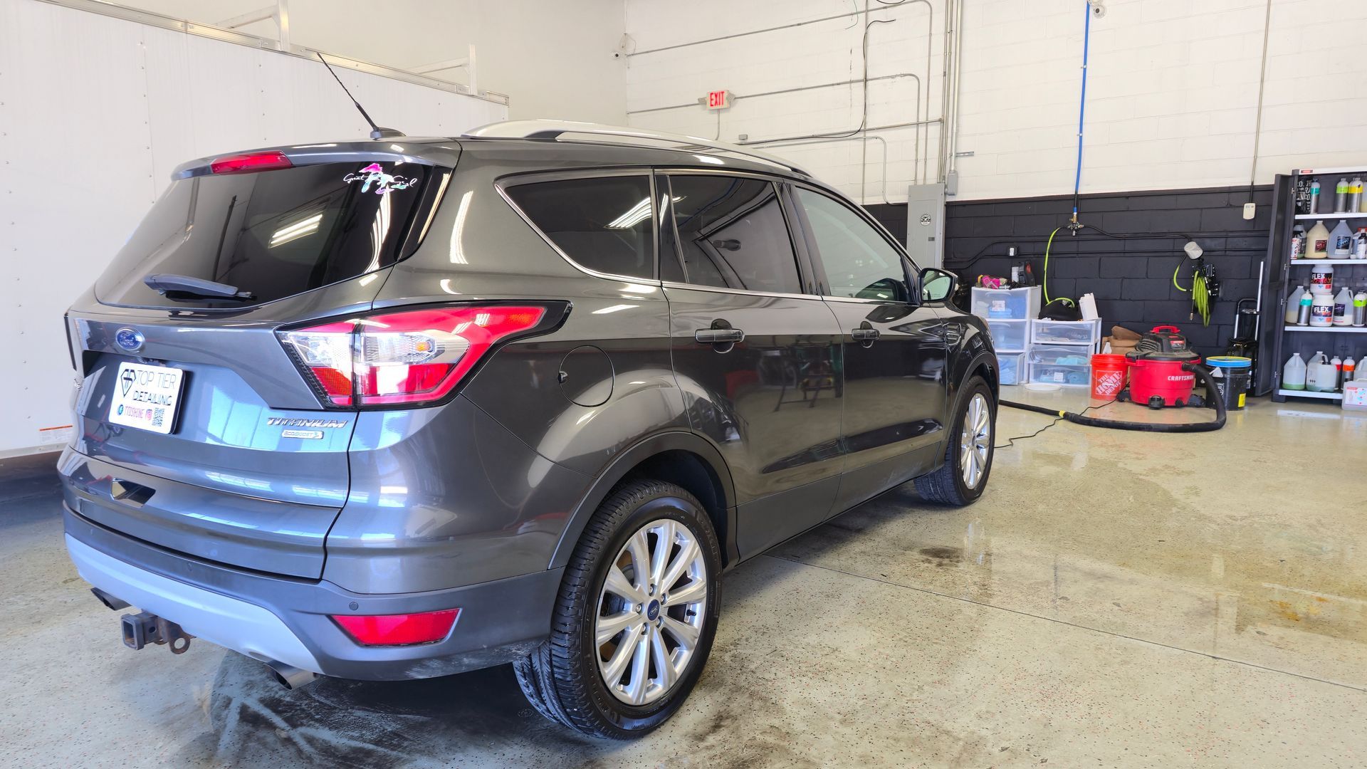 Gray Ford Escape SUV inside a car wash bay.