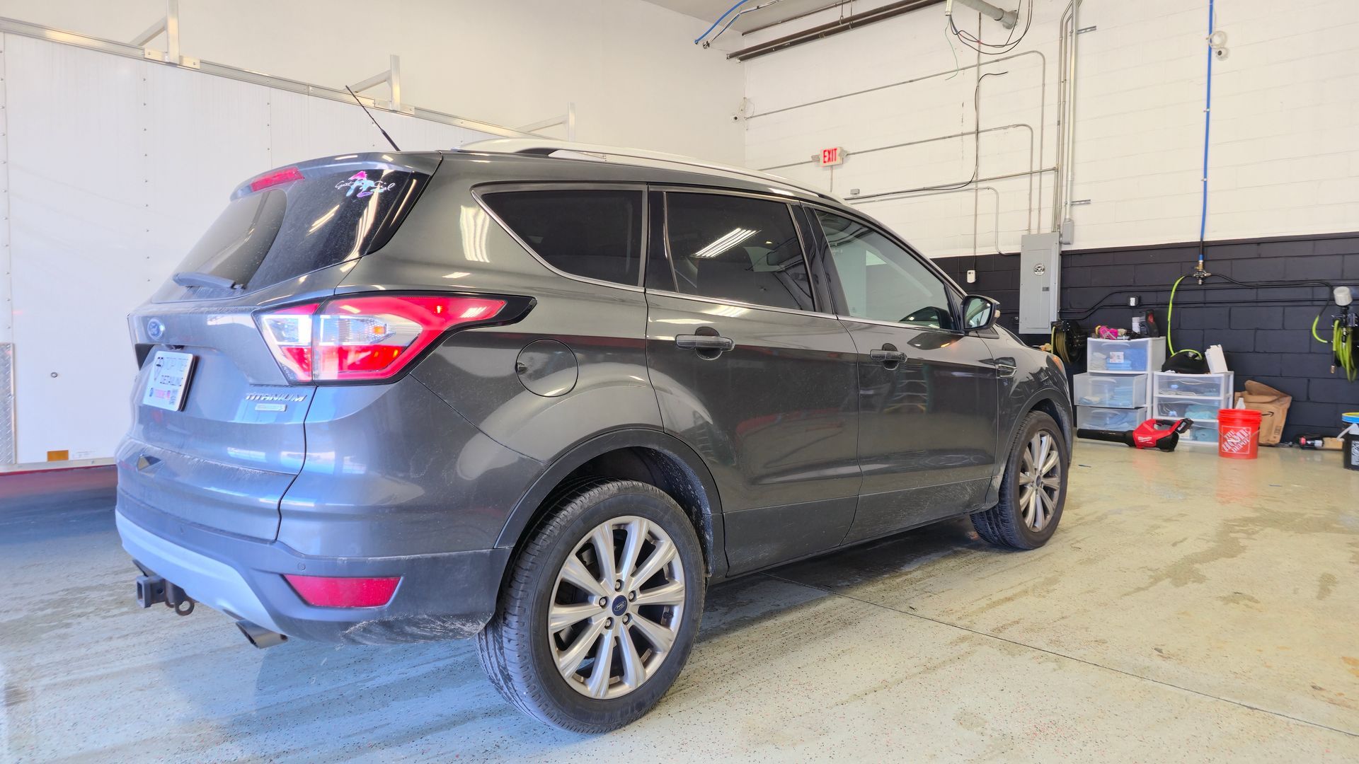 Dark gray Ford Escape SUV inside a garage.
