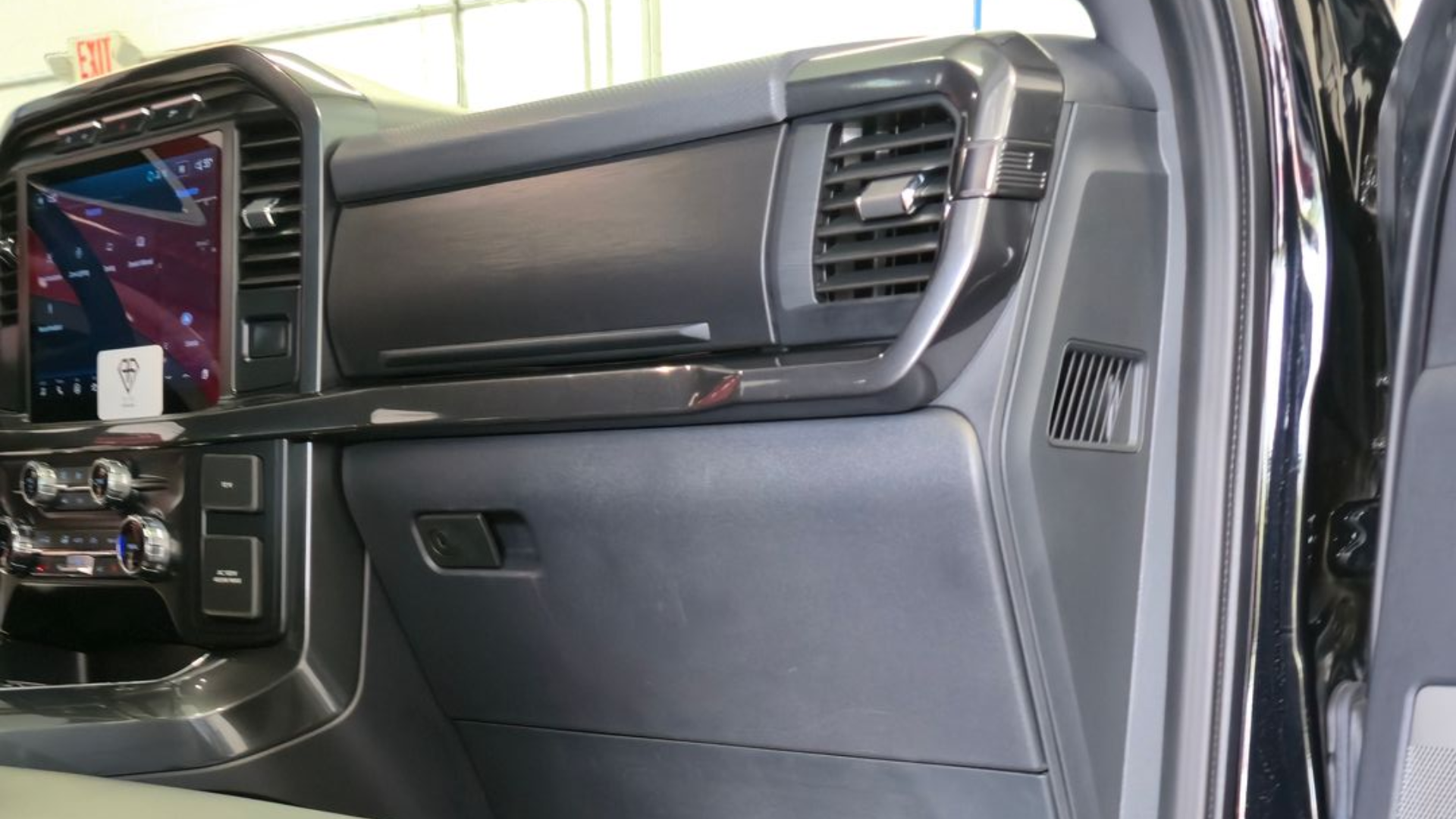 Interior view of a black pickup truck with black leather seats and floor mats.