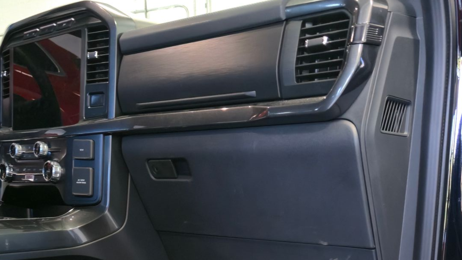 Interior of a black truck. The dashboard and driver's seat are visible.