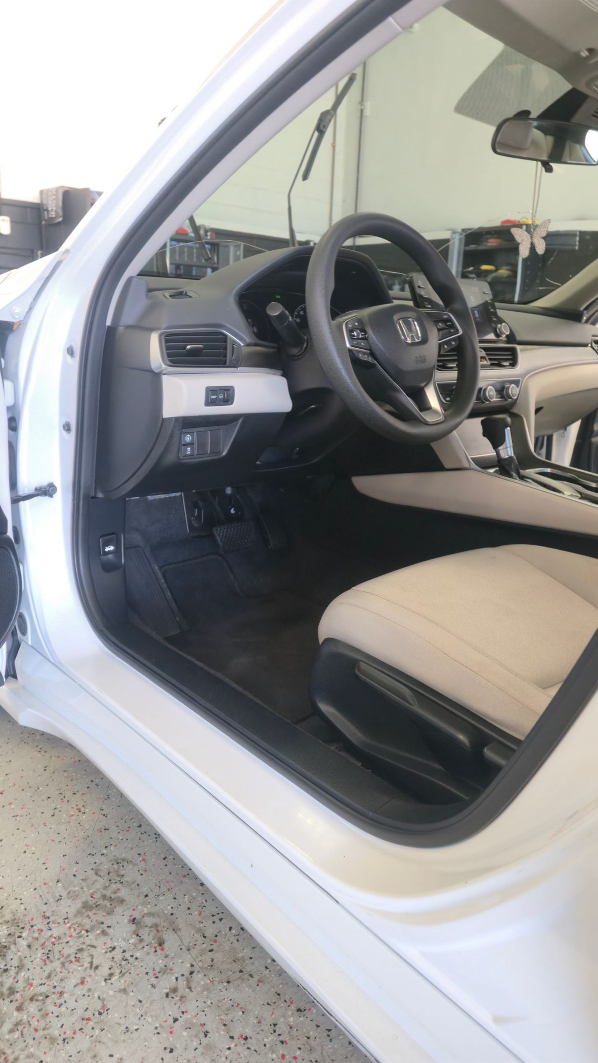 Silver SUV with trunk open, interior visible; back door open, detailing shop in background.