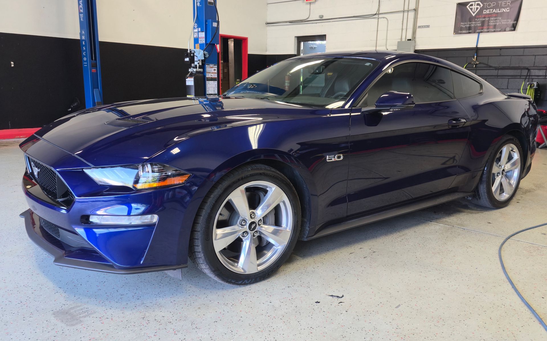 Blue Ford Mustang car in a garage.
