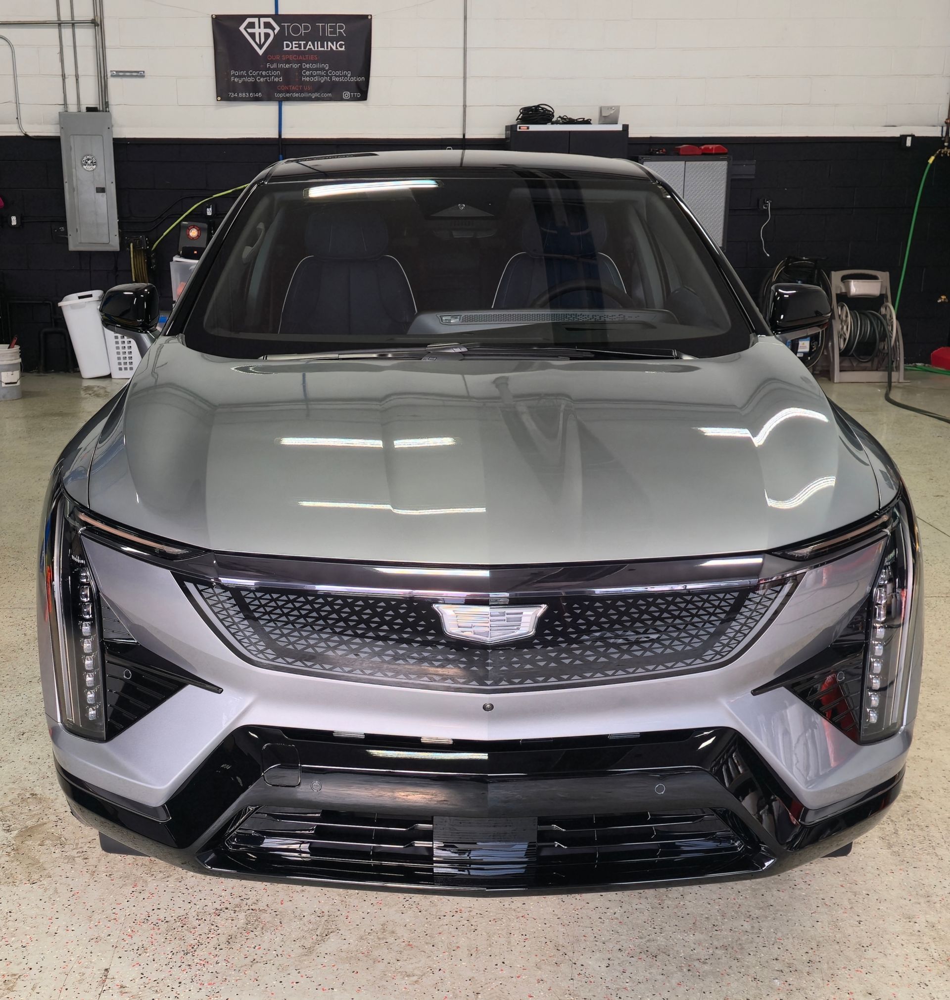 Silver Cadillac SUV in a garage.